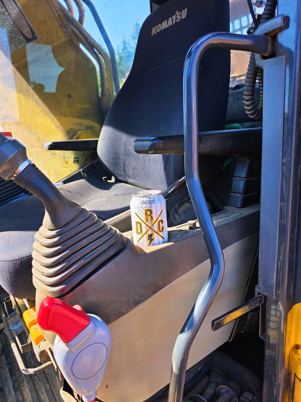 Electric Citrus can sitting on the console of a Komatsu excavator